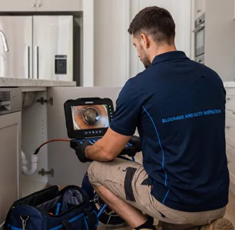 Plumber clearing a blocked toilet in a Marayong bathroom